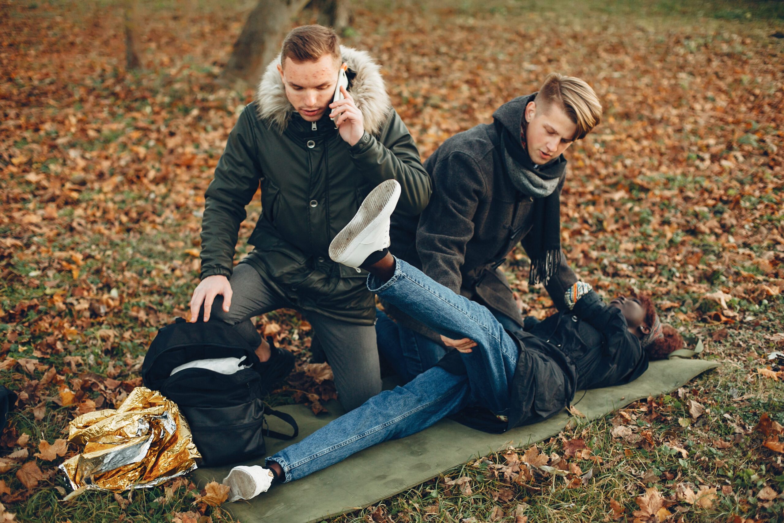 Two boys in a autumn park help a african girl